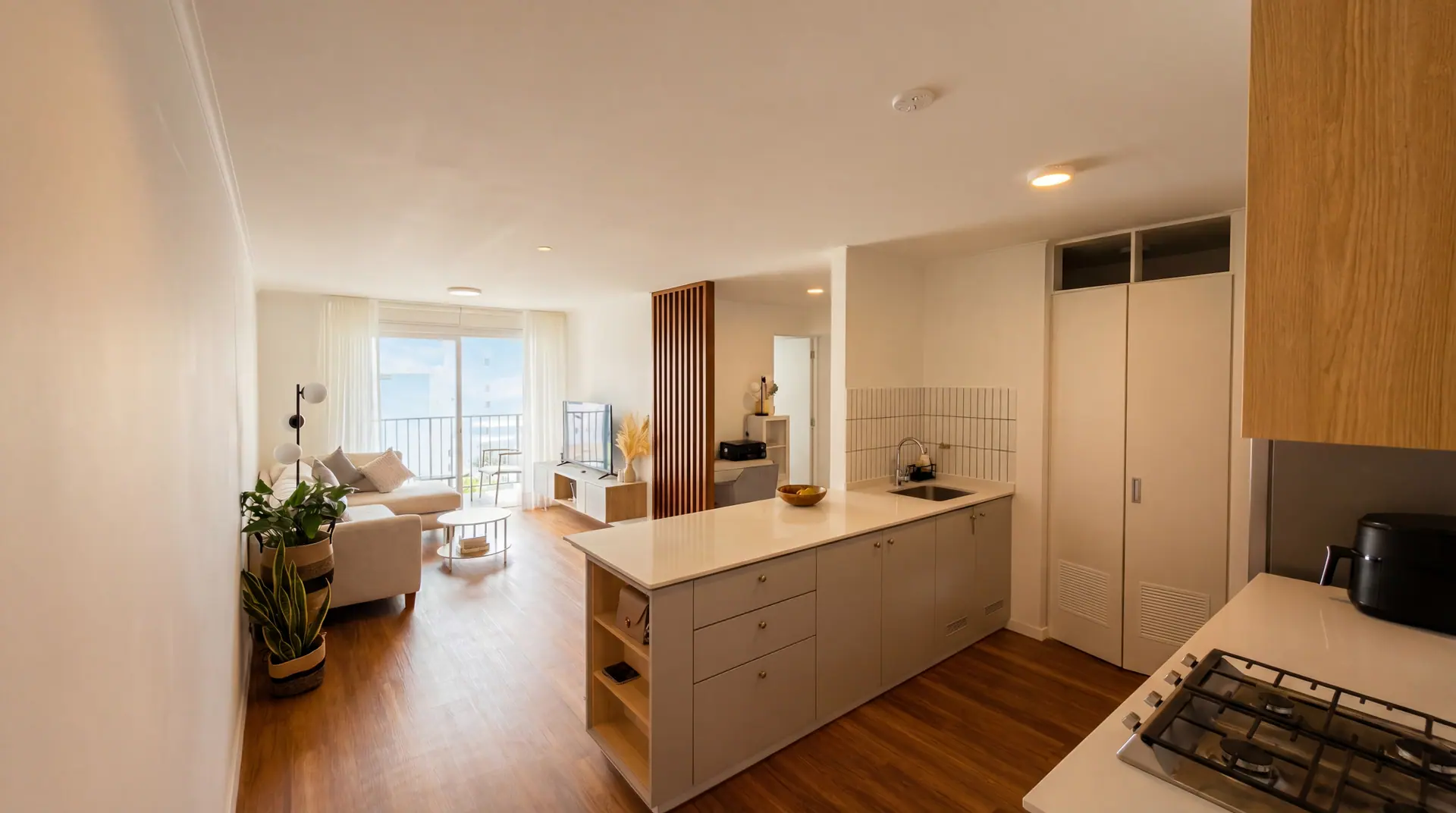 Sala y cocina integradas de un departamento de dos dormitorios administrado por Maison Nova en Lima